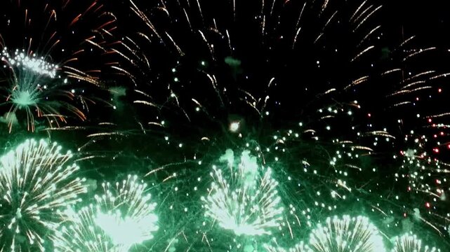 Colorful bursts of light illuminate dark sky, creating mesmerizing spectacle. This breathtaking display captivates audience, filling air with excitement and joy during grand celebration.