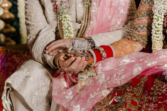Elegant Wedding Rituals: Bride and Groom Exchange Vows in Opulent Ceremony with Intricate Jewelry, Traditional Attire and Soft Hues. Celebrating Love and Unity