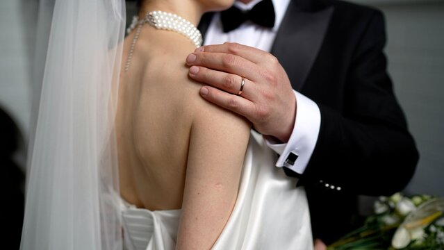 Groom gently touching bride's shoulder on wedding day