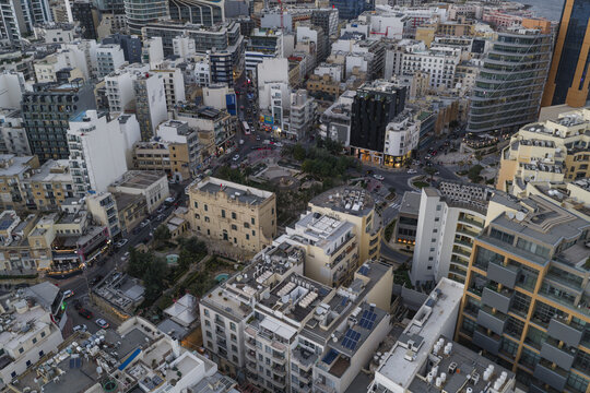 Aerial view of buildings casting soft shadows under the muted light, revealing the urban tapestry of St. Julian's, Sliema, Malta.