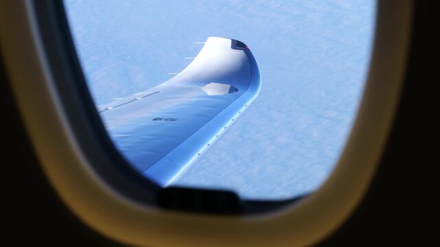 passenger window aircraft winglet gleaming bright daylight above soft blanket clouds cruise conditions high altitude smooth view sky horizon flight aviation travel sunlight blue 