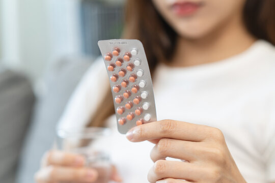 young female holding birth control pills