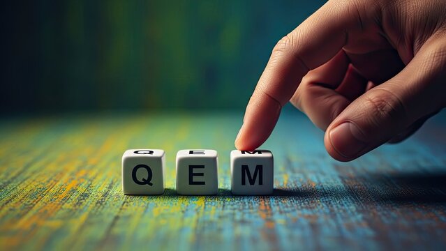 Hand Arranging QEM Scrabble Style Letters on Colorful Textured Background