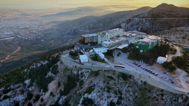 The drone executes a lateral flight keeping Regency Casino Mont Parnes centered in frame while gradually descending.