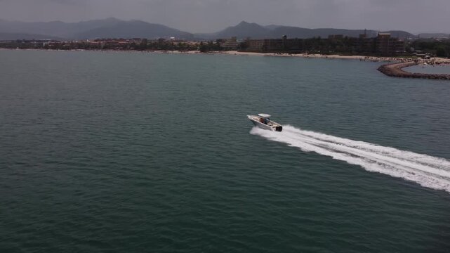 A speedboat racing across the sea with the city of Lecher&iacute;a in the background, located in Venezuela