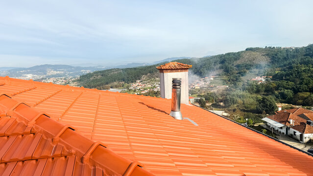 House roof with smoking chimney
