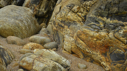 Rocks of different compositions, textures and strata eroded on the shores of the ocean. 