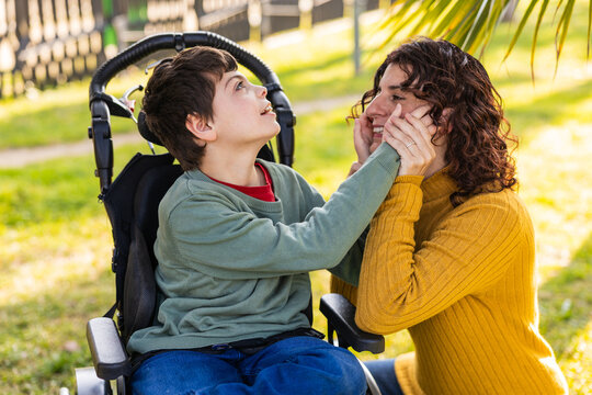 child playing with mother outdoors in wheelchair, cerebral palsy and intellectual disability awareness