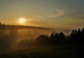 Obraz premium Beautiful view of the sunrise in the mountains, the landscape is covered in fog.