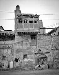Weathered brick building with carved wooden balcony