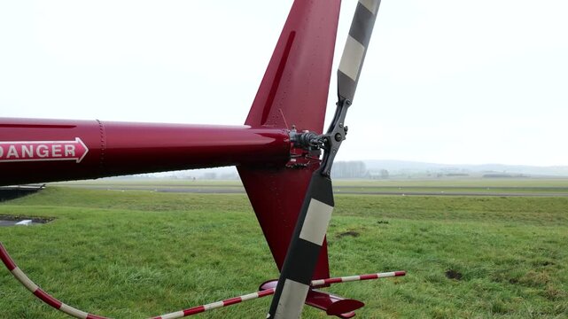 helicopter section red boom warning markings exposed rotor hub blades vertical stabilizer skid support resting up close tail reichelsheim airfield germany 