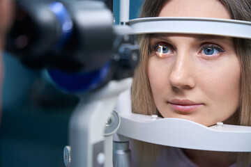 Young woman is diagnosed with eye pressure on special ophthalmological equipment
