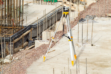 Construction surveying, leveling instrument on tripod used to mark elevations along reinforced...