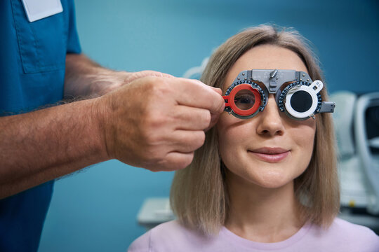 Happy cheerful woman looking at eye test chart in the ophthalmology center