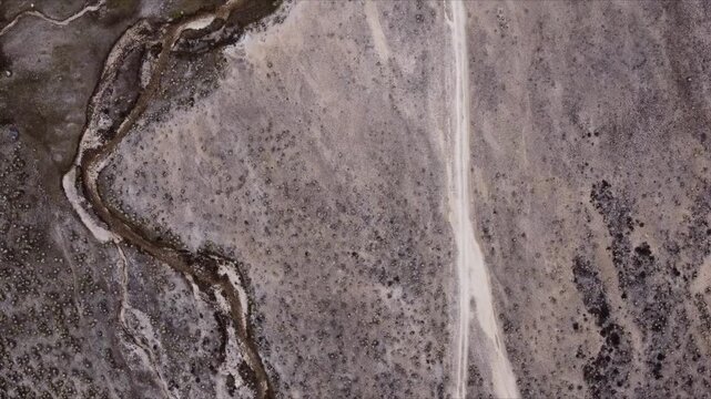 Aerial shot taken with a drone of a rocky high mountain road, notable for its visual textures and endemic vegetation