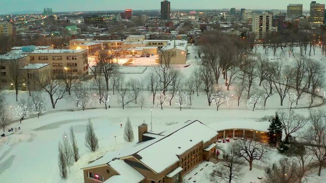 drone flying over lake in park lafointaine montreal some people ski also main restaurent n big goverment building in winter
