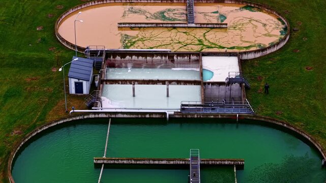 Drone establishing shot of a municipal treatment plant with interconnected tanks