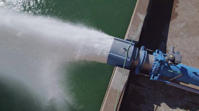 Howell Bunger valve in operation. Aerial view. Pressurized water outlet from dam wall. Water flowing from pumping in reservoir. Hydropower station pumping water. Water outlet from dam wall.