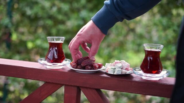 Dry Dates in a bowl and tea in armudu glass. Ramadan kareem.  Outdoor  background.