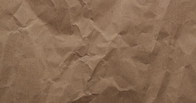Stop-Motion Crumpled Kraft Paper Texture. Rapid stop-motion animation quick successive changes of wrinkled brown kraft paper osurfaces, creating dynamic textured transitions with visible creases.