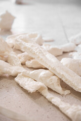 White expanding spray foam insulation pieces on floor