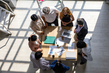 Fototapeta premium Top view of Team of business office workplace with team meeting for upcoming project for marketing and sale management with skyscraper view for startup and entrepreneur concept