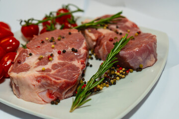 Fototapeta premium Juicy steak on a plate with fresh rosemary and cherry tomatoes, ready to serve