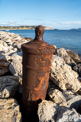 Old rusty cannon embedded in an artificial stone cliff near Methoni Castle, Greece