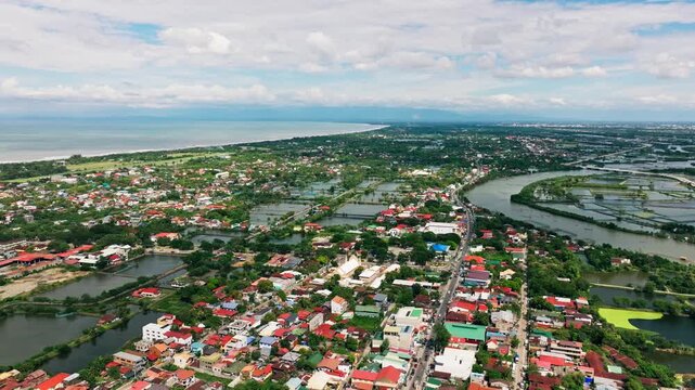 Aerial panoramic view of Lingayen coastline, Basing River under cloudy blue sky