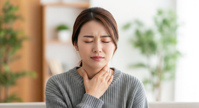 A woman appears to be experiencing throat discomfort or pain.