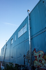 Obraz premium Blue corrugated metal building with graffiti