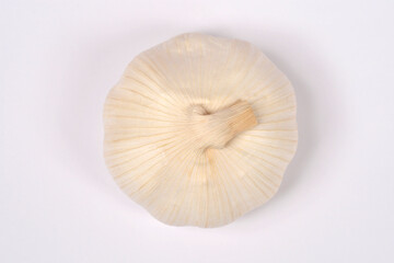 A top view of a whole fresh white garlic bulb isolated on a plain white background