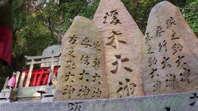 Stone steles with Japanese Kanji inscriptions and a Kitsune Fox statue at Fushimi İnari, Kyoto