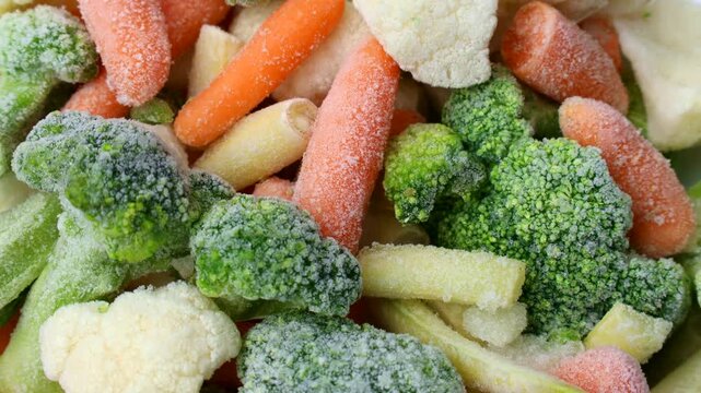 Assorted frozen vegetables (broccoli, carrots, cauliflower, beans) circle rotation close up