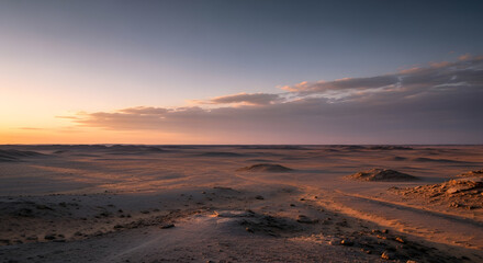 Wide angle view of an arid desert environment with rolling sand hills and a gradient sky during twilight