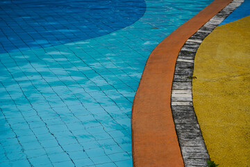 Obraz premium Vintage swimming pool curve with blue tiles and yellow concrete geometric background 