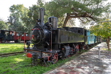Obraz premium Well-preserved historic locomotive photographed outdoors in Greece under clear daylight.