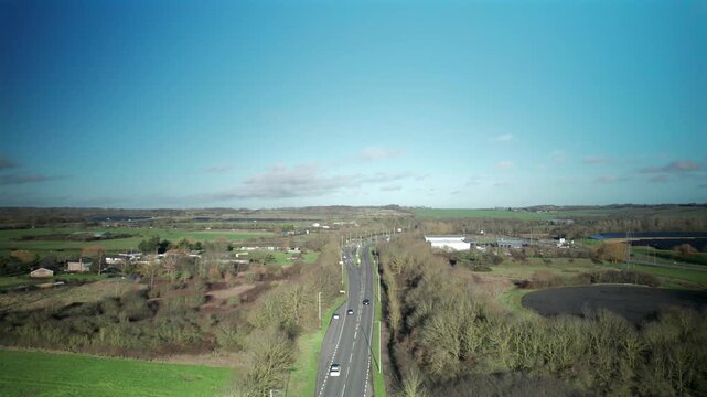 Aerial Drone Footage Of The A127 Arterial Road Motorway In Distance, Clear Blue Sky, Basildon, Essex