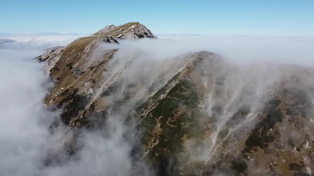 Drone aerial of Mount Stol (Hochstuhl) ridge wrapped in clouds