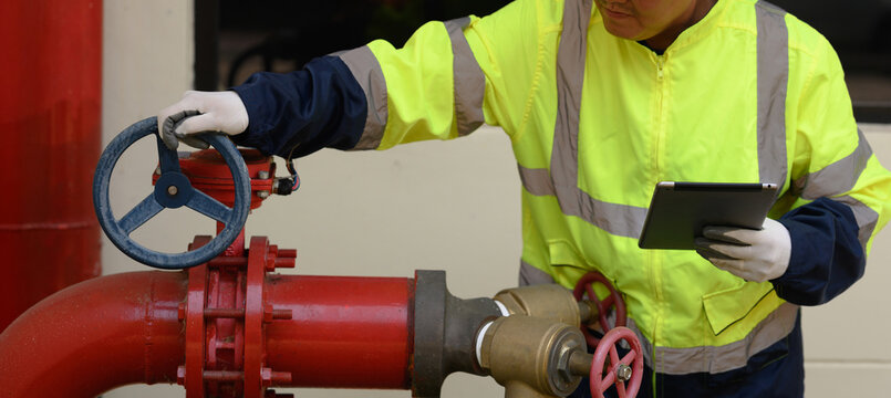 Technicians are inspecting the fire pump system of a large building.	