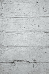 Obraz premium A close view of a light gray brick wall with textured and peeling paint.