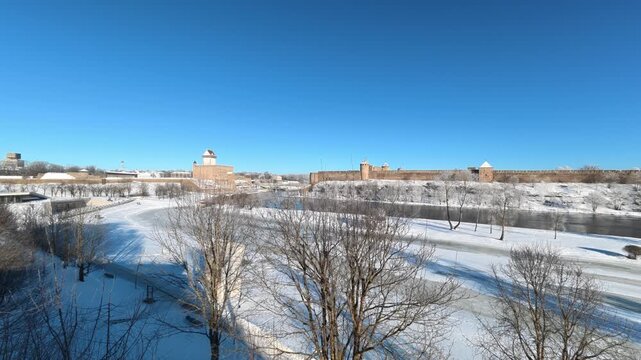 Narva, Estonia &ndash; February 2026: Morning mist rising over the Narva River near the historic Ivanogorod Fortress on the Russia&ndash;Estonia border during winter sunrise.