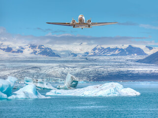 A twin-propeller plane is flying over the glacier Lagoon Jökulsarlon in Iceland - Vatnajoekull glacier in Iceland deep blue ice © muratart