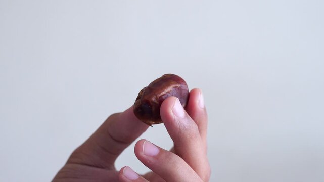 Muslim man eating date to break fast during ramadan iftar at home
