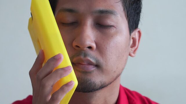 sad man holding ice pack on her head