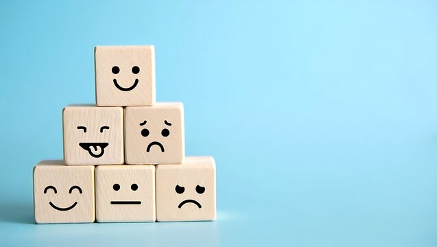 Stacked Wooden Blocks Showing Various Emotional Faces Arranged Pyramid Style