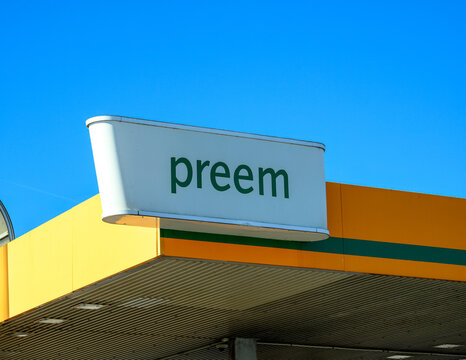 Falkenberg, Sweden, april 3-2025: Bright yellow and green gas station signage features the word Preem under a clear blue sky. The structure is modern, displaying a welcoming 