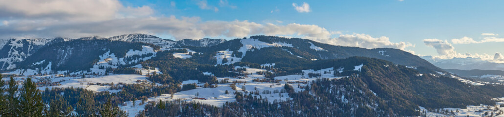 Winter landscape at the foot of the Nagelfluhkette with the snow-covered Hochgrat peak above Steibis near Oberstaufen in the Allg&auml;u region of Bavaria, Germany, under soft afternoon light.