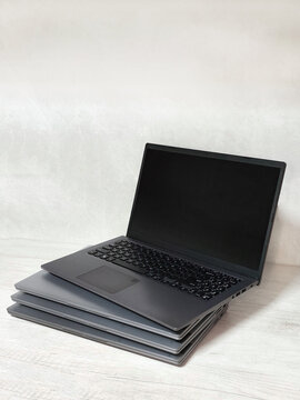 stack of laptops on a gray background, on the table, laptop computer, tablet, business, work, remote work, freelance.
