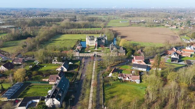 direct approach aligns castle laarne perfectly central garden axis fortress surrounded by protective moat from overhead long drone shot of belgium tree-lined avenue 